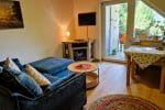 Blick auf Kuschelsofa, Kamin, Smart-TV und Balkon
